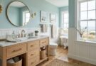 Coastal calm bathroom featuring soft blues and greens, white shiplap walls, and a light oak vanity.