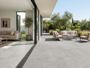 Seamless flooring transition from indoor living room to outdoor patio with large format grey porcelain tiles