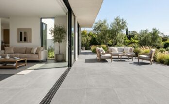 Seamless flooring transition from indoor living room to outdoor patio with large format grey porcelain tiles
