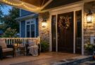 Front porch at dusk with sconces and warm fairy lights enhancing the ambiance.