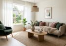 Modern Scandinavian living room with light oak floors, white walls, streamlined sofa with sheepskin, and jute rug.