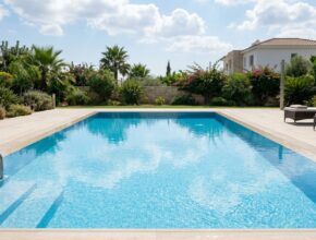 Serene saltwater swimming pool with clear, sparkling blue water and a modern light-colored pool deck.