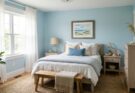 Coastal serene bedroom with Palladian Blue walls, light wood furniture, seagrass rug, and white sheer drapes.