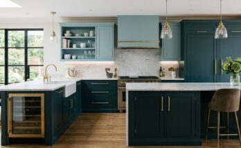 Luxurious kitchen with deep teal base cabinets and lighter teal upper cabinets with brushed brass.