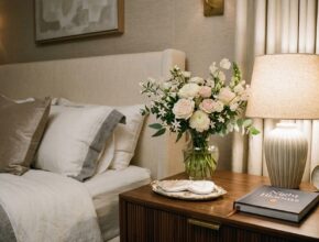 A nightstand adorned with a small, elegant bouquet of fresh flowers, adding natural beauty and luxury to a hotel-style bedroom.