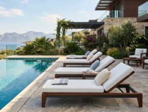 Premium poolside furniture made from teak and powder-coated aluminum with plush, quick-drying cushions for a resort feel.
