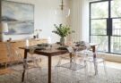 Clear acrylic 'ghost chairs' tucked under a dining table in a small dining room.