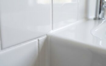 Close-up of freshly cleaned and re-grouted bathroom tiles and caulking.